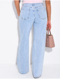 Jeans à coutures effilochées et clous sur les poches