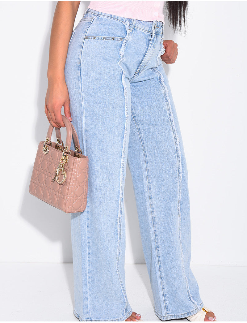 Jeans à coutures effilochées et clous sur les poches